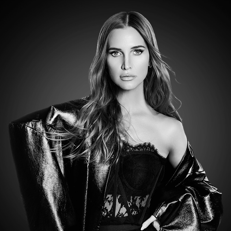 Black and white promotional image for Ashlee Simpson’s “I Am Me” show featuring the artist in a shimmering outfit on a dark gradient background. Text displays show dates: January 23–24 and January 30–31, 2026.